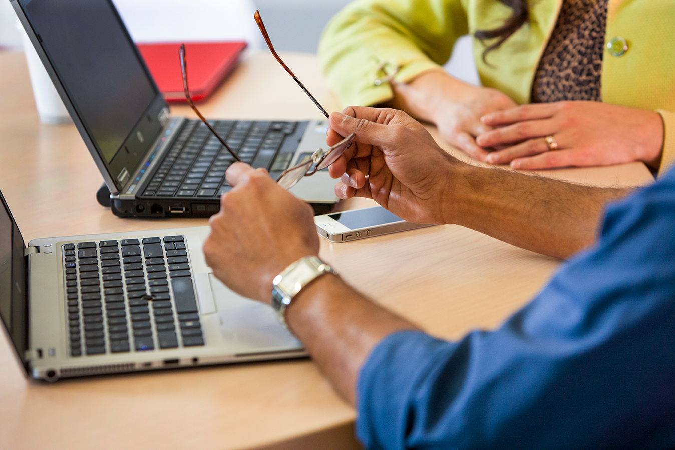 The laptops and hands of two Lilly employees collaborating on a project