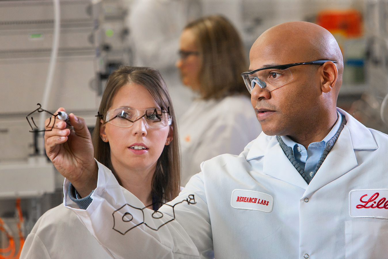 Two Lilly employees working on a whiteboard